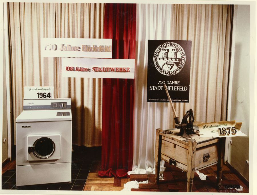 Eine moderne Waschmaschine von 1964 und eine alte Waschmaschine von 1875 stehen im Schaufenster.