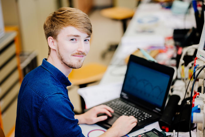 Junger Mann arbeitet an einem Laptop