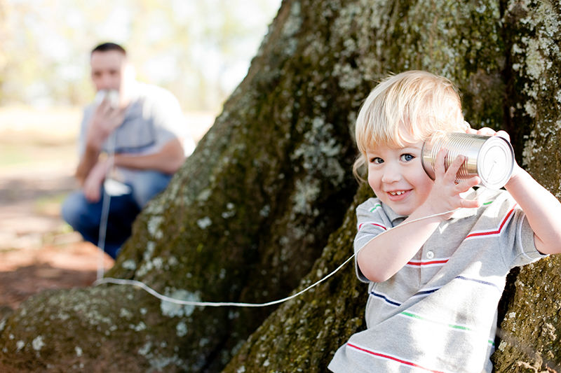 Das Foto zeigt zwei Kinder, die sich über eine Schnutelefon unterhalten. Das Foto ist von istockphoto.com, von Patrick Heagney.