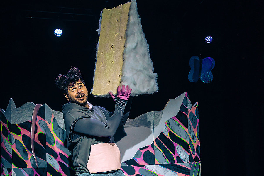 Ein Schauspieler steht auf einer Bühne.